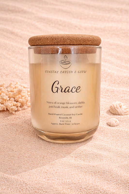 'Grace' candle on a sandy background with shells and starfish. Orange Blossom, Dahlia, Patchouli, Musk, and Amber Scent