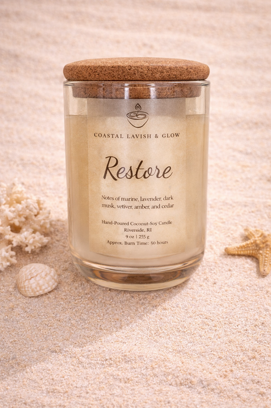'Restore' Candle with cork lid on a sandy background. Notes of Marine, Lavender, Dark Musk, Vetiver, Amber, and Cedar.