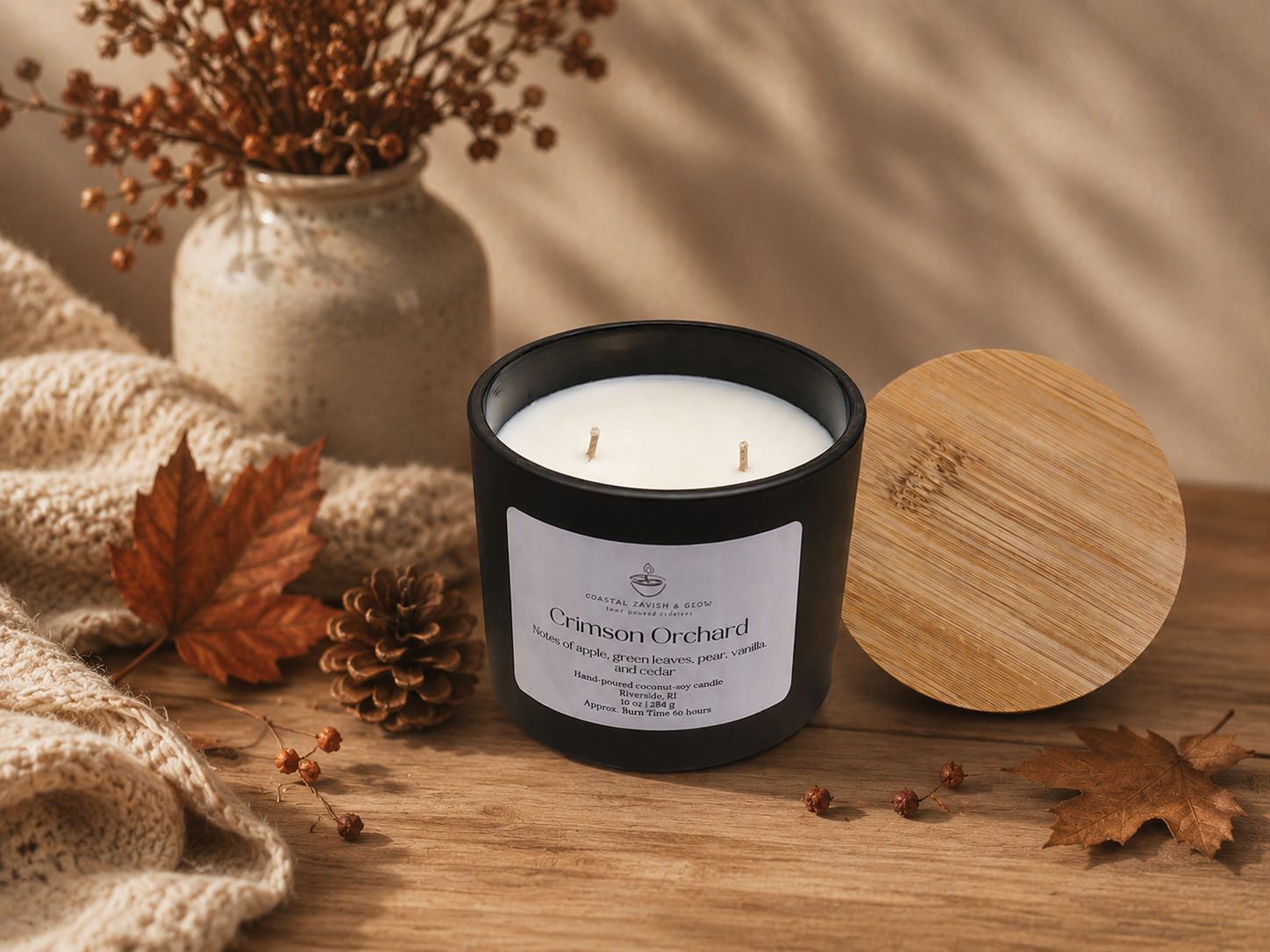 Candle labeled 'Crimson Orchard' on a wooden surface with decorative elements.