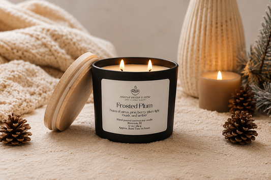 "Frosted Plum" candle set in a cozy winter background with pinecones