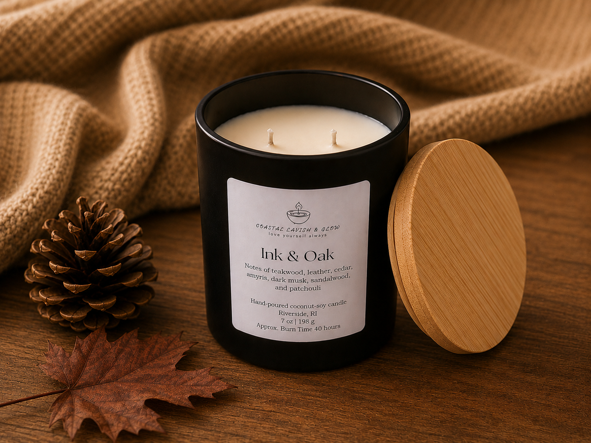 Candle labeled 'Ink & Oak' with a wooden lid and pine cone on a wooden surface