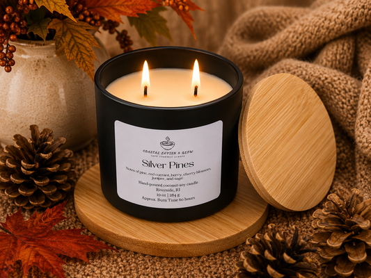 Candle labeled 'Silver Pines' with a wooden lid on a decorative surface with fall elements.